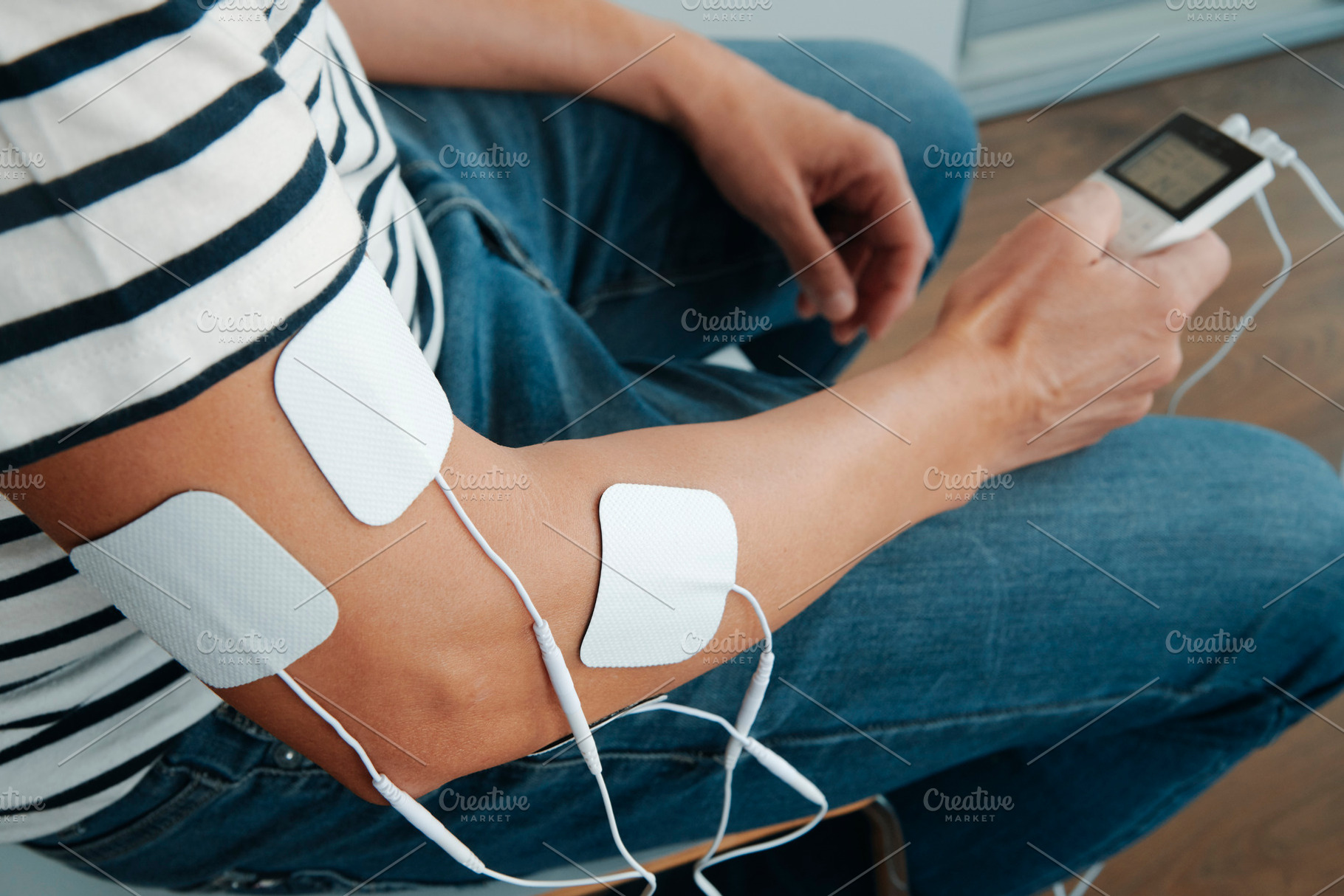 electrode pads attached to the arm of a man, a Photo by Nito