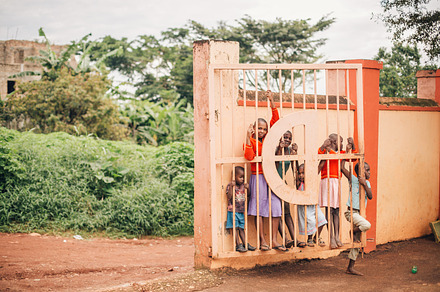 African Kids Play Behind a Gate