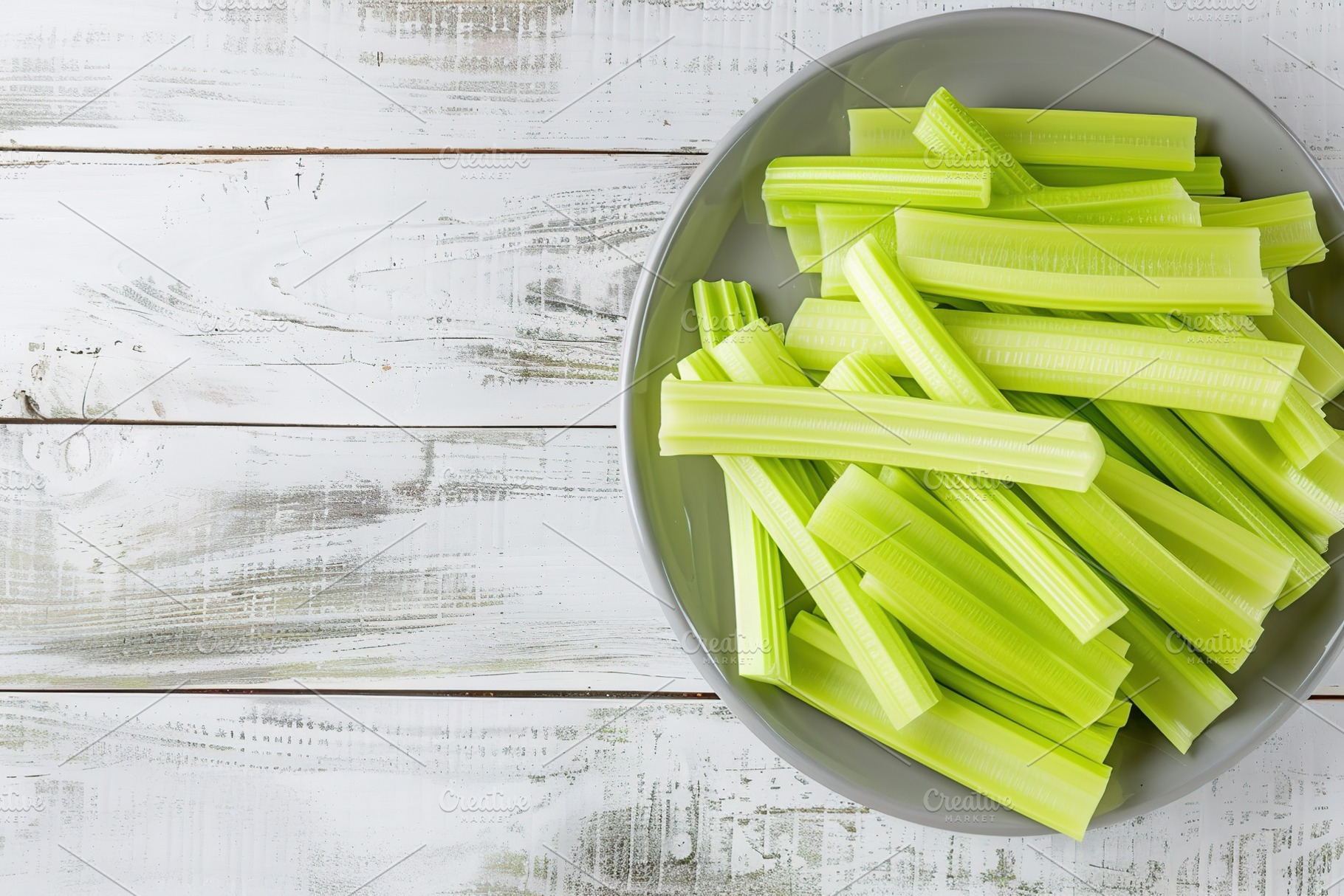 Green fresh celery pieces in bowl on wooden background, a Food & Drink Photo by AlyaAnd
