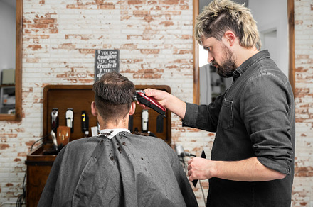 Man barber cutting hair of male client with clipper at barber shop. Hairstyling, a Person Photo by david.herraez.calzad