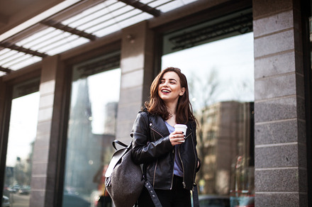 The concept of street fashion. portrait of Young girl dressed in a fashionable outfit. Posing against the window of the boutique, a Beauty & Fashion Photo by Grabovskaya