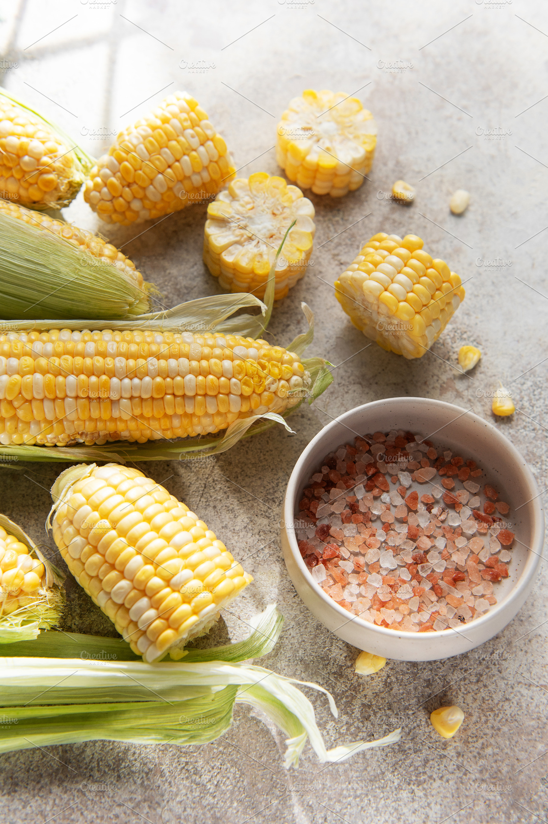 Fresh sweet corn cobs with salt on table, a Food & Drink Photo by Olena Rudo