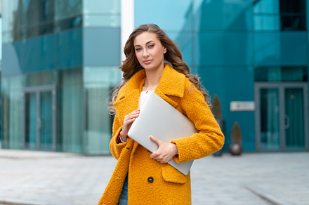Business woman with laptop dressed yellow coat standing outdoors corporative bu, a Person Photo by andreonegin market