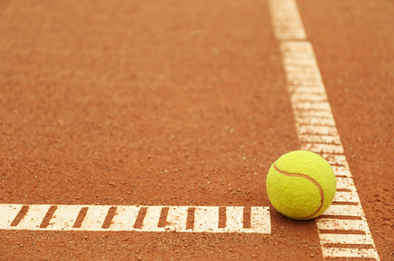 Light green tennis ball on clay court, space for text, a Sports & Recreation Photo by AtlasStudio PRO