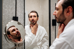 Man wearing a white bathrobe looking