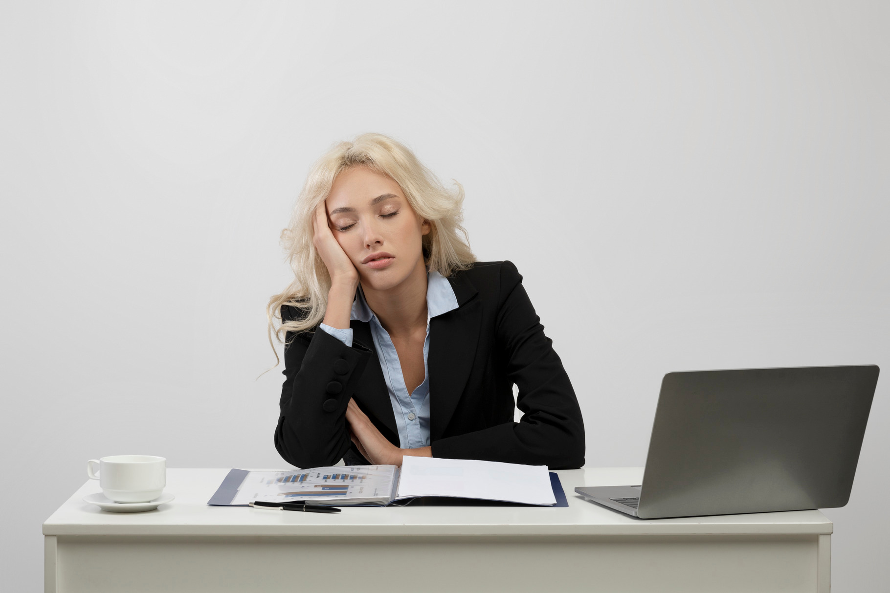 Tired young businesswoman sleeping on her desk in front of laptop ...