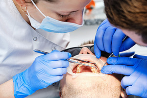 Close-up of a dental team performing a check-up with modern equipment and safet, a Health & Medical Photo by Rohan Photography