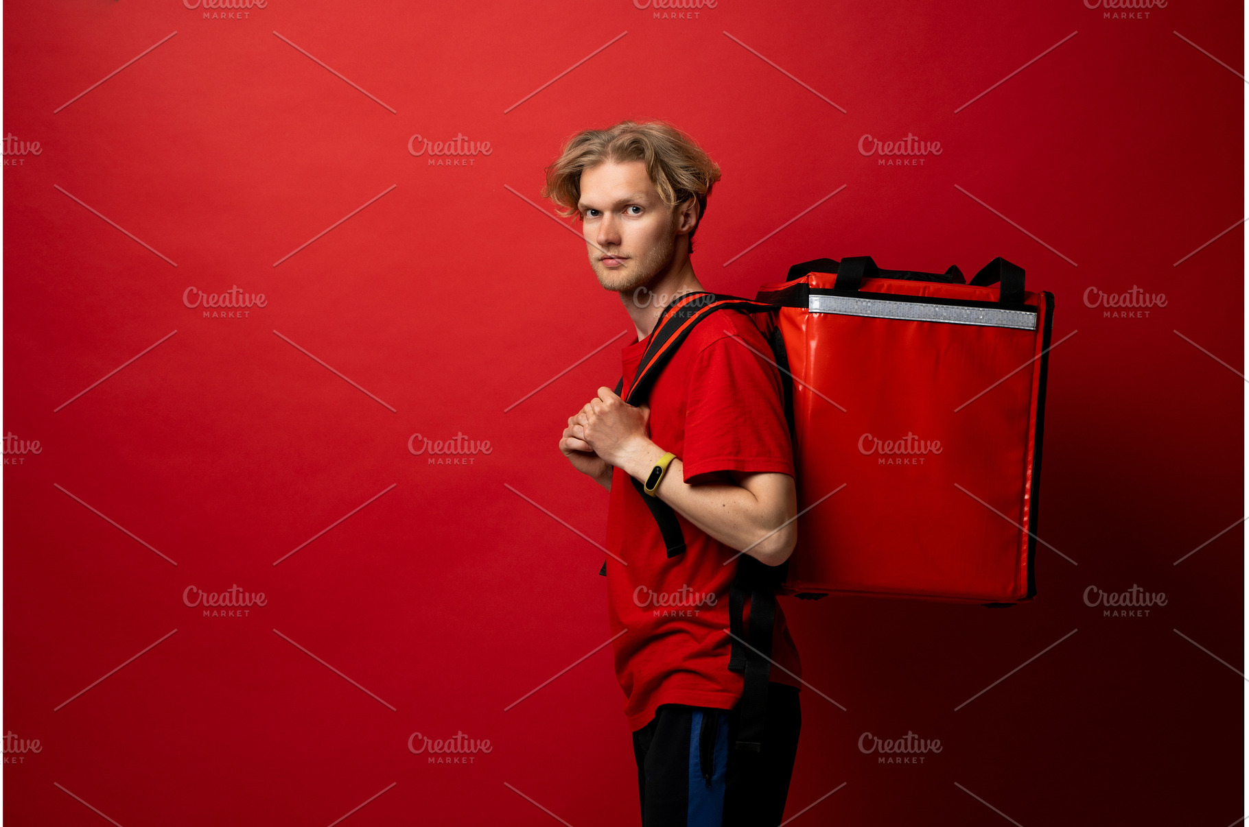 Young courier man in red t-shirt, a Person Photo by volodymyrshtun13795
