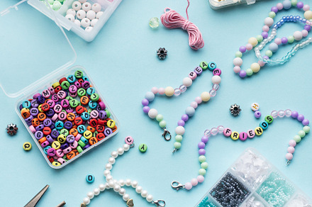 Colorful assortment of beads and jewelry-making tools on a blue, an Arts & Entertainment Photo by Olena Rudo
