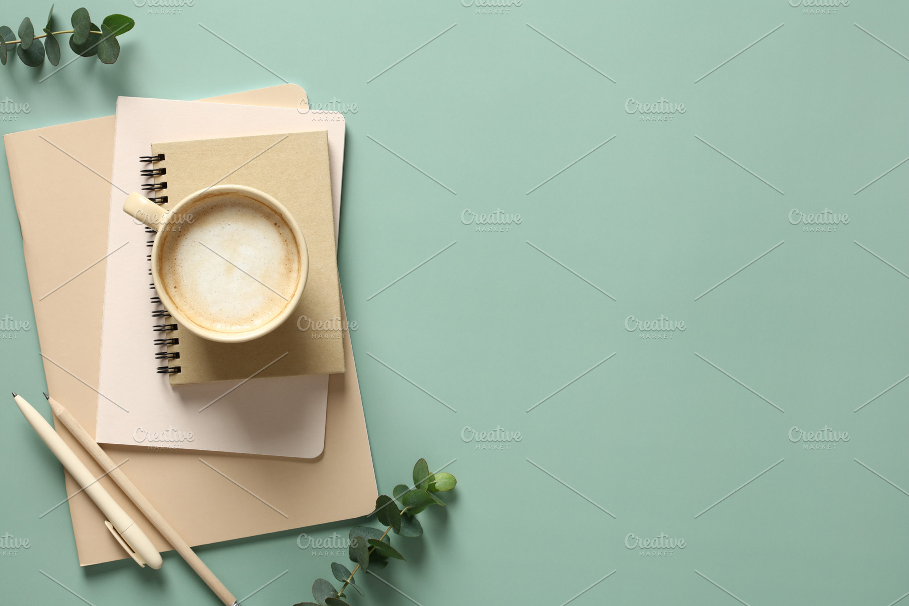 Stack of notebooks, cup of coffee and office supplies on a green background wit, a Holiday Photo by photoguns