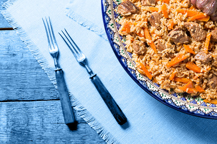 Pilaf in handmade plate on wooden ba, a Background Photo by Kate Molchanova