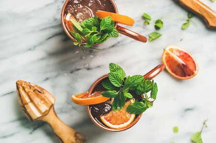 Blood orange Moscow mule alcohol cocktails, marble background, square crop, a Food & Drink Photo by Foxys