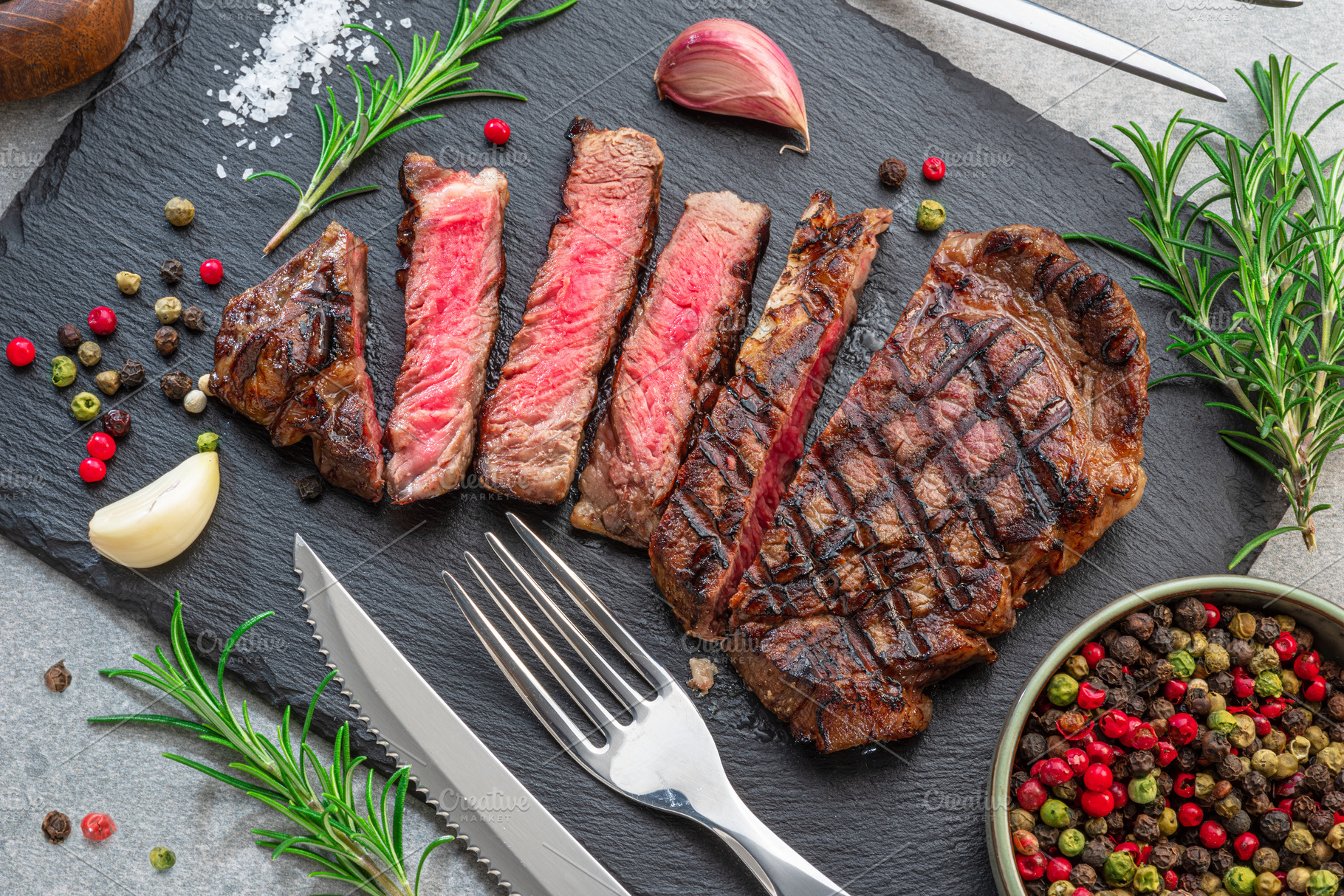 Grilled delicious ribeye steak slices and some seasonings on bl, a Food & Drink Photo by Volff