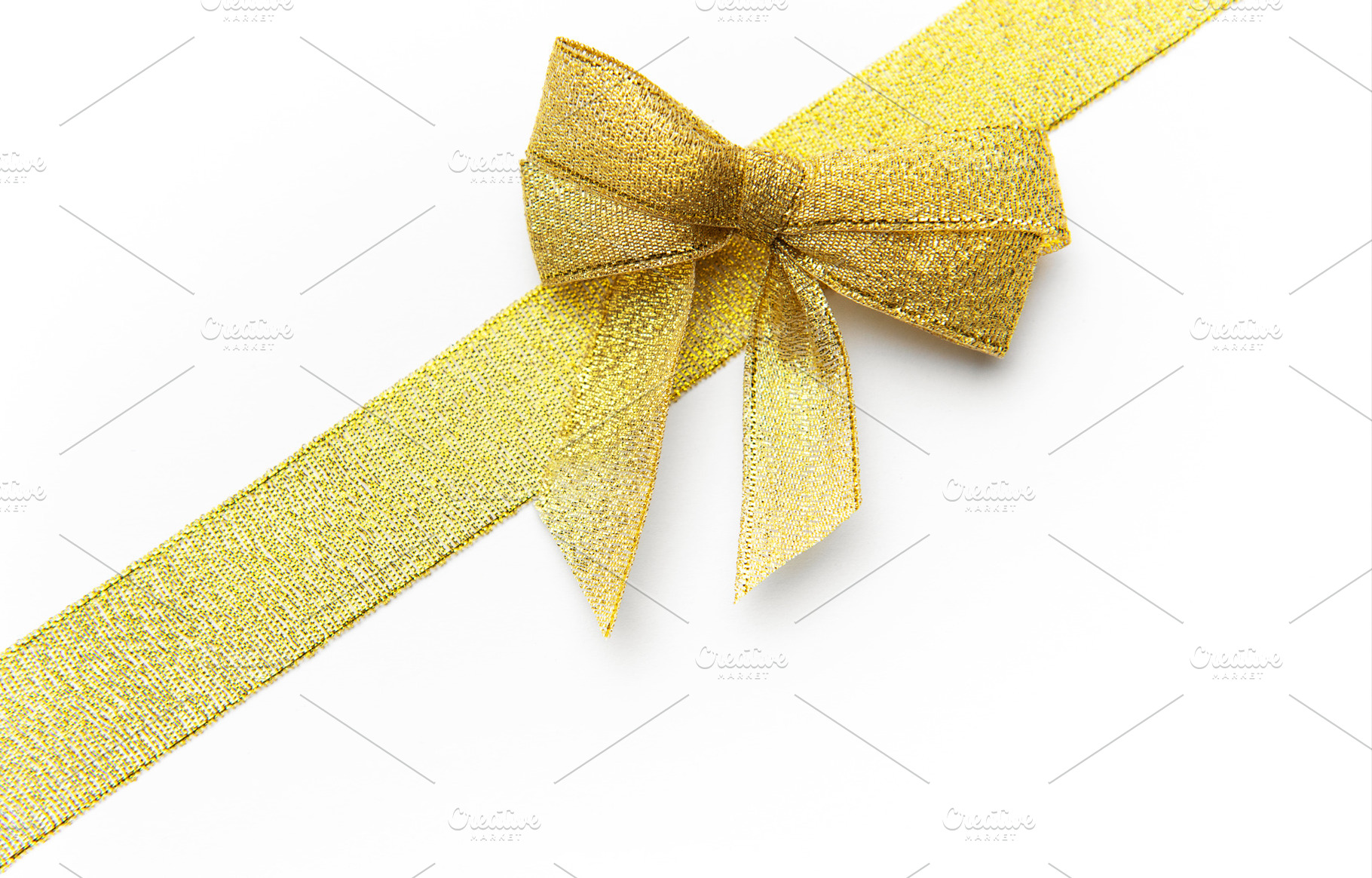 Gold glitter ribbon and bow on white background, a Holiday Photo by Olena Rudo