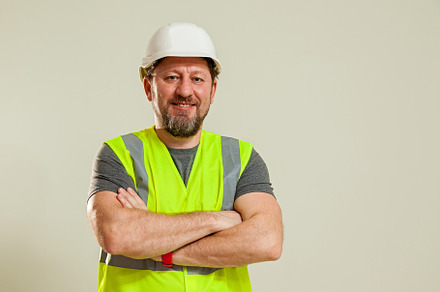 worker in a vest and white helmet, a Person Photo by Photostock