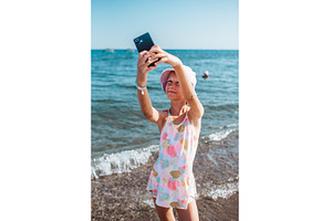 Girl taking selfie on beach with, a Sports & Recreation Photo by HalfPoint