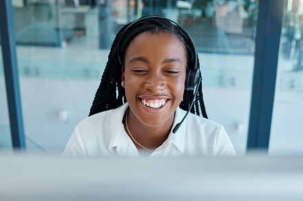 Call center, happy and black woman with a smile for telemarketing, customer service and consulting on a computer. Crm, working and African consultant talking and giving support to people on internet, a Photo by Peopleimages.com