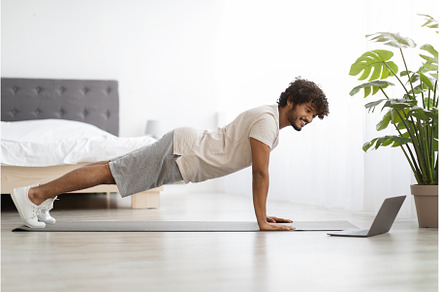 Happy athletic hindu man planking at, a Sports & Recreation Photo by Prostock-Studio