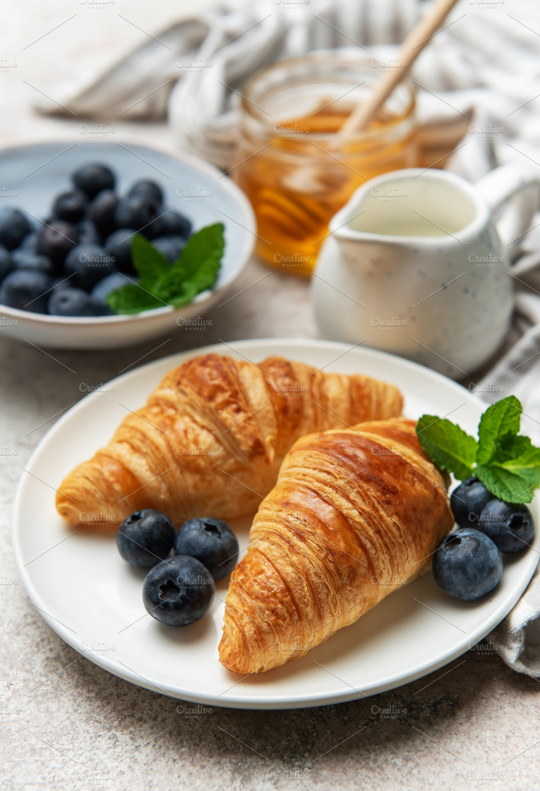 Delicious french croissants with fresh blueberries and honey for, a Food & Drink Photo by Olena Rudo