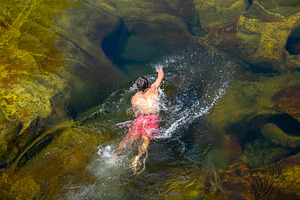 Man swimming in clear natural pool, a Nature Photo by DanFLCreativo