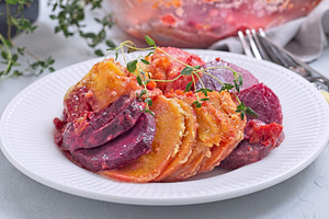 Sweet potato, parsnips and beet root gratin with thyme and melted cheese, on wh, a Food & Drink Photo by iuliia_n