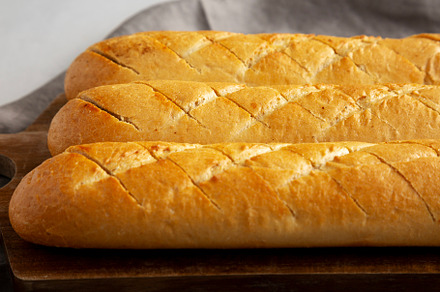 Homemade French Baguette with Garlic Filling on a wooden board,, a Food & Drink Photo by LiudmylaChuhunova