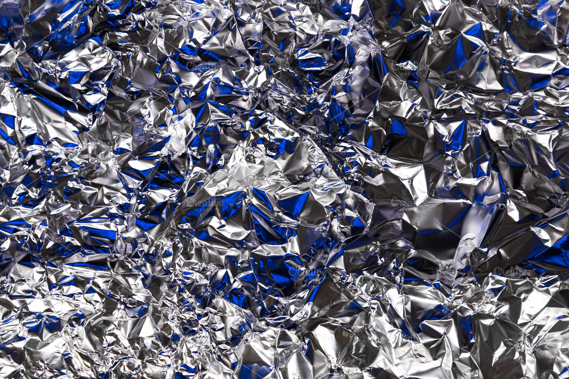 Shiny crumpled silver foil with blue, an Abstract Photo by Edalin's Store