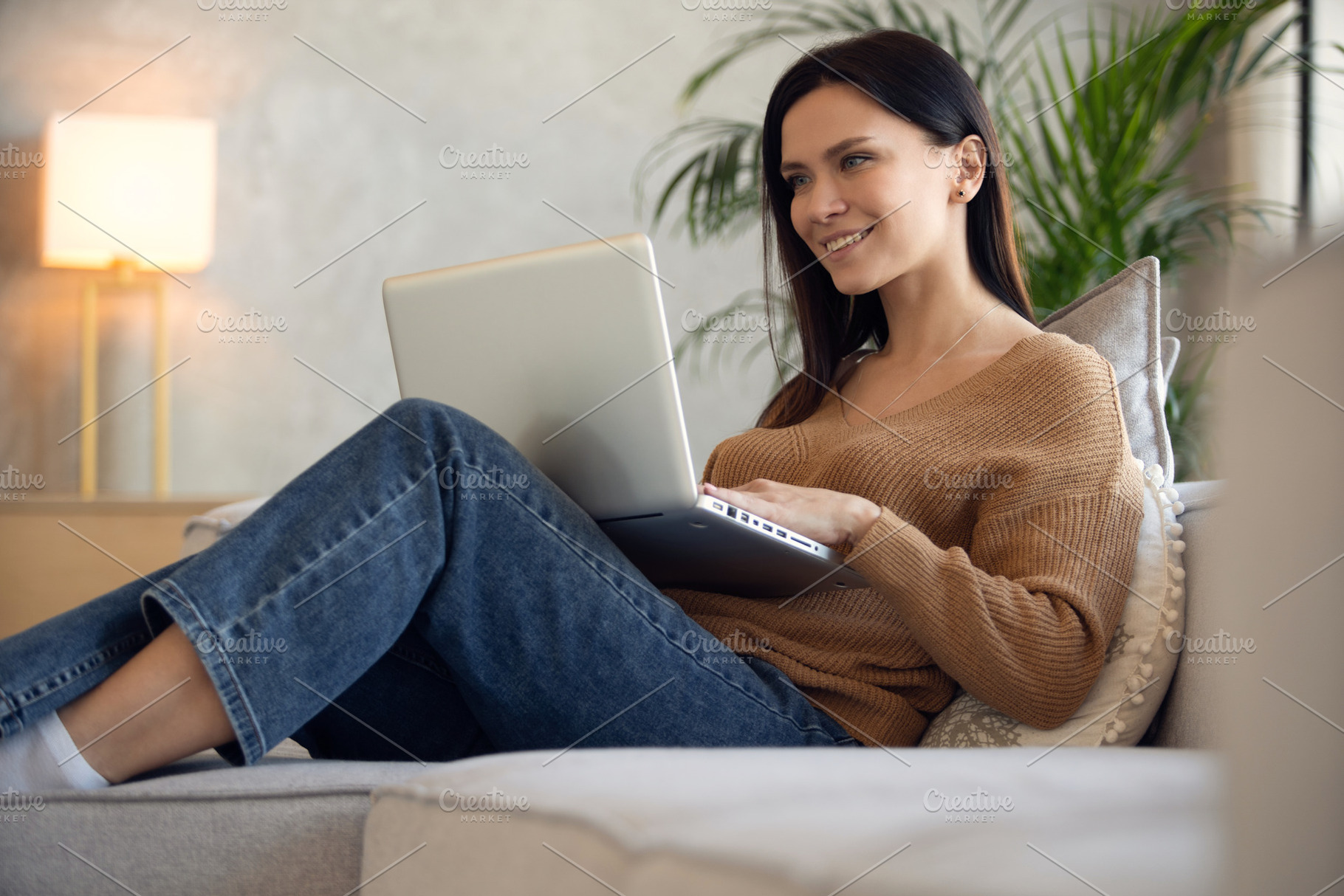 Smiling woman using laptop, a Person Photo by OPOLJA