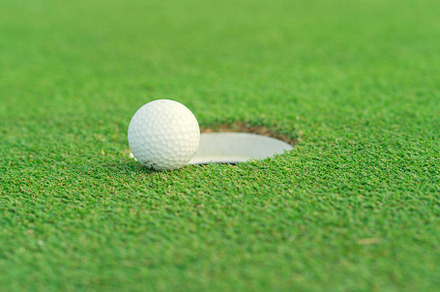 Golf ball on lip of cup at golf court, a Sports & Recreation Photo by Casanowe-studio