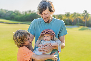 Father, son, and newborn on a meadow, a Person Photo by Elizaveta Galitskaya