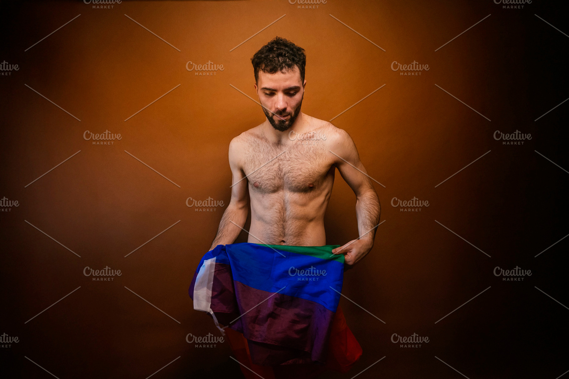 Man expressing lgbt identity holding pride flag, a Photo by karrastock