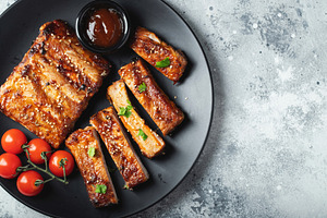 Closeup of pork ribs grilled with BBQ sauce and caramelized in honey., a Food & Drink Photo by Budarinphoto