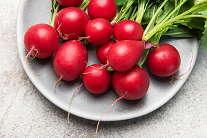 Fresh red radishes with green leaves on plate, a Food & Drink Photo by Olena Rudo