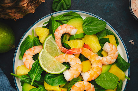 Pineapple salad with shrimps, spinach, avocado and lime on blue, a Food & Drink Photo by 5PH