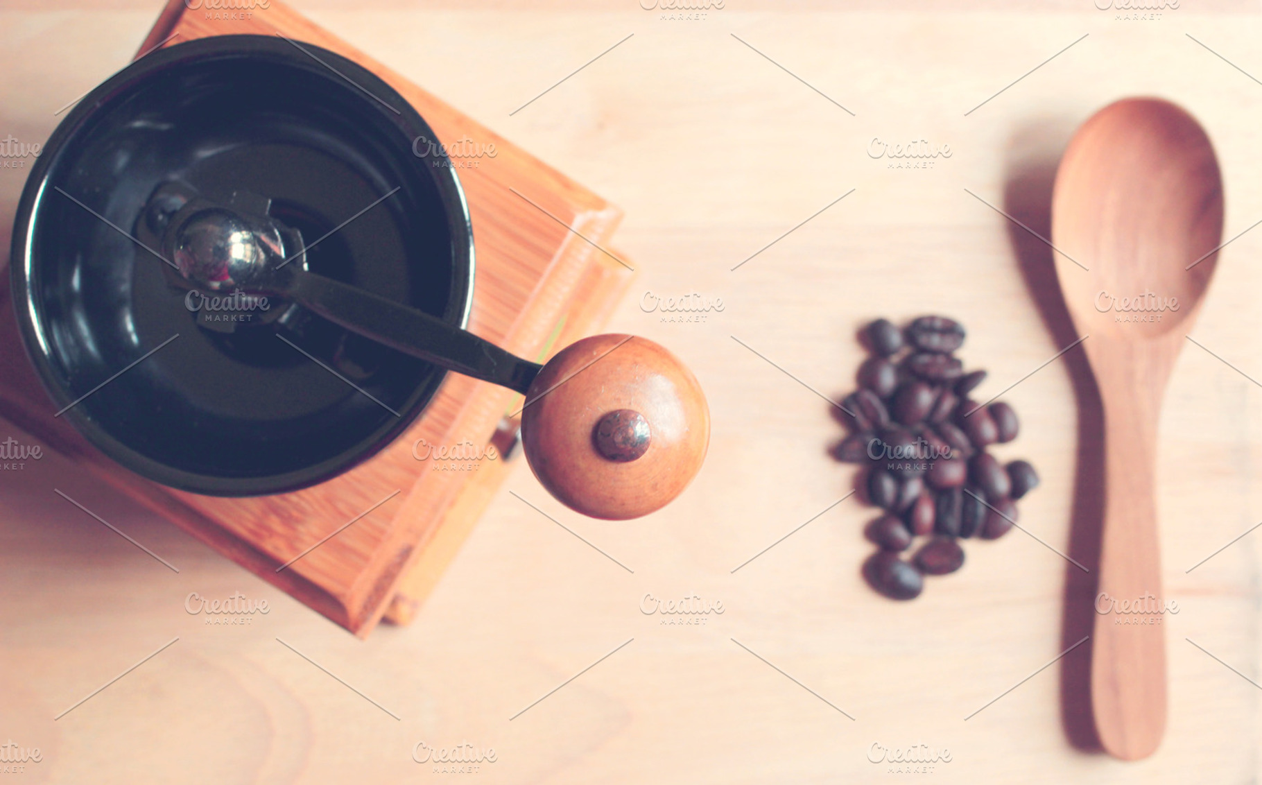 Coffee grinder and spoon containing wood, coffee, and coffee grinder