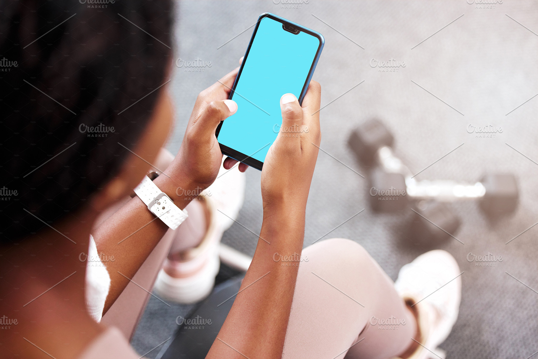 Fitness, smartphone in hands and mockup with green screen, black woman and app for exercise and weightlifting with dumbbell in gym. Sports marketing, wellness and phone with virtual workout class., a Photo by Peopleimages.com