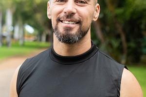 Confident male personal trainer smiling at camera outdoors in park, a Sports & Recreation Photo by etorres69