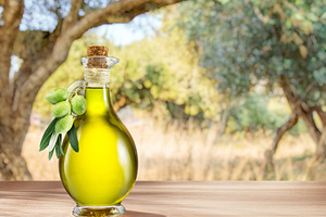 Bottle of craft farm olive oil stands on a wooden table., a Food & Drink Photo by Volff