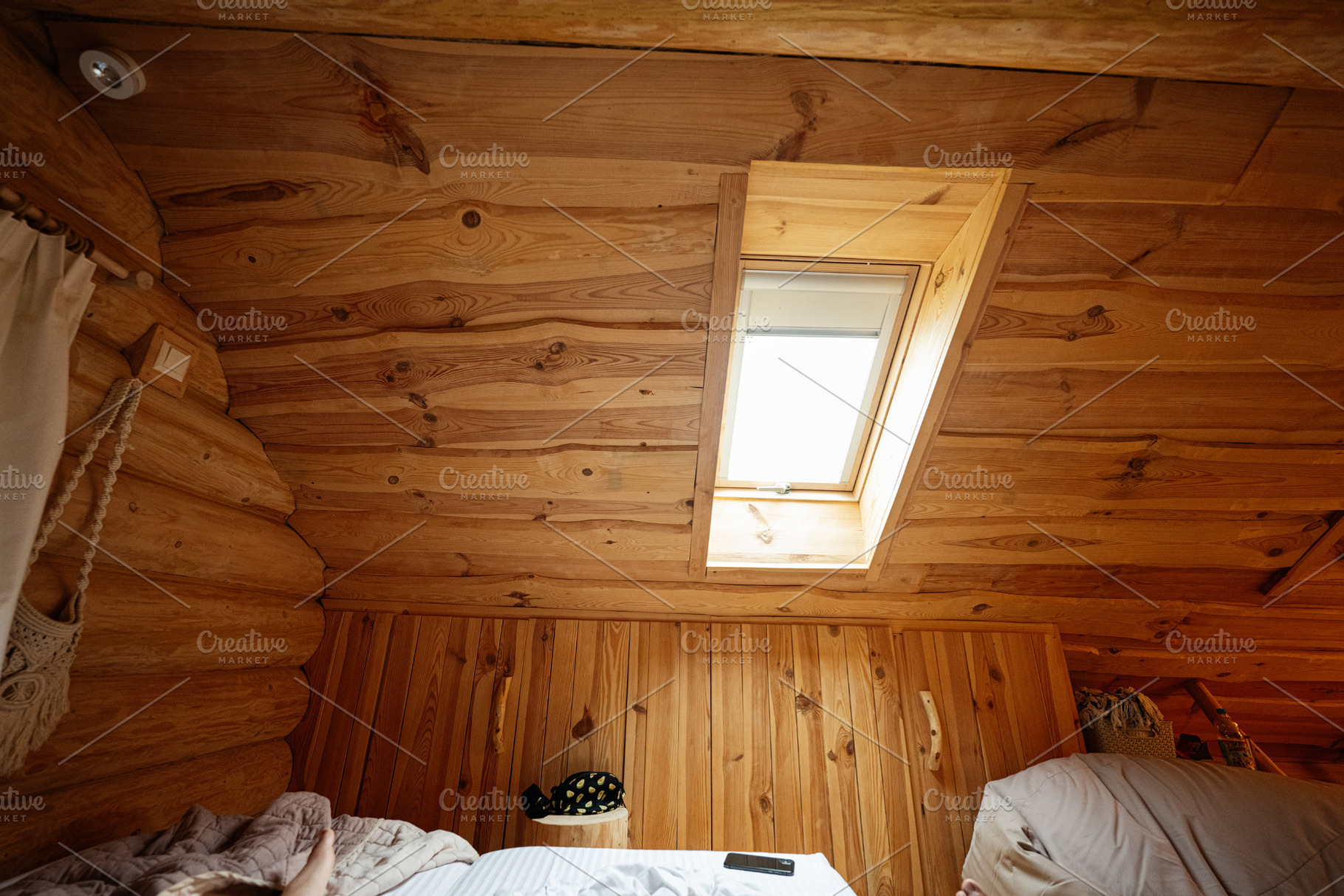 Cozy wooden attic with sunlight entering through a skylight window, a Photo by AS photostudio