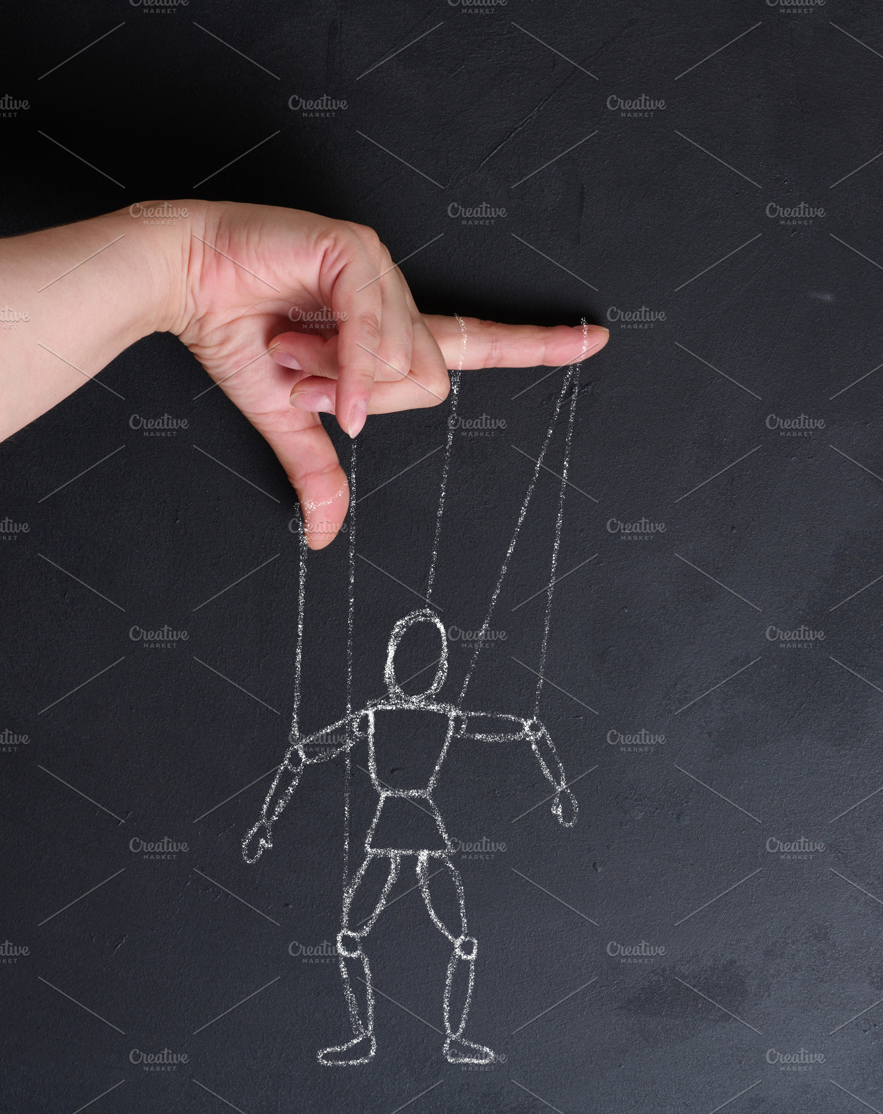 Conceptual image of manipulation, a human hand holding strings l, a Person Photo by ndanko
