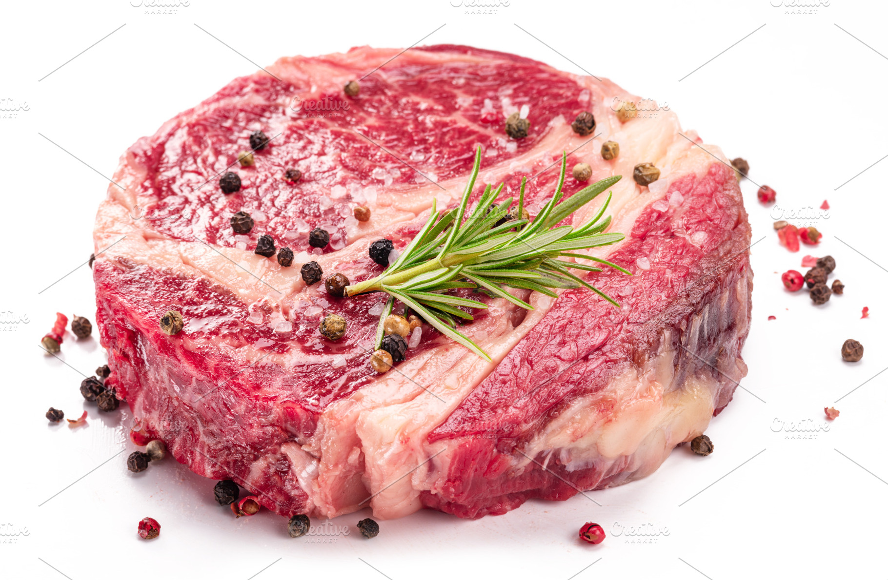 Raw beef steak with herbs and spices ready for cooking on white, a Food & Drink Photo by Volff