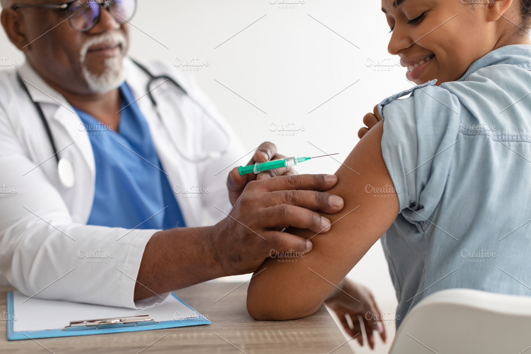Black Woman Receiving Coronavirus Vaccine Injection Sitting With Doctor Indoor, a Photo by Prostock-Studio