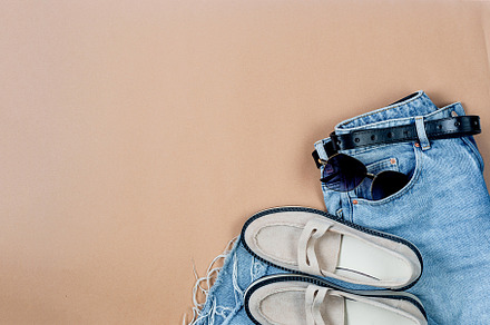 Blue jeans, beige suede loafer or flat shoes lying and sunglasse, a Photo by vimart