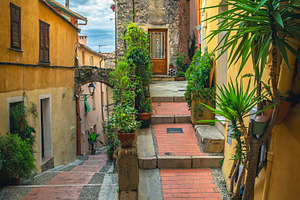 Cozy narrow street in Menton, France, an Architecture Photo by Alpine Dreams
