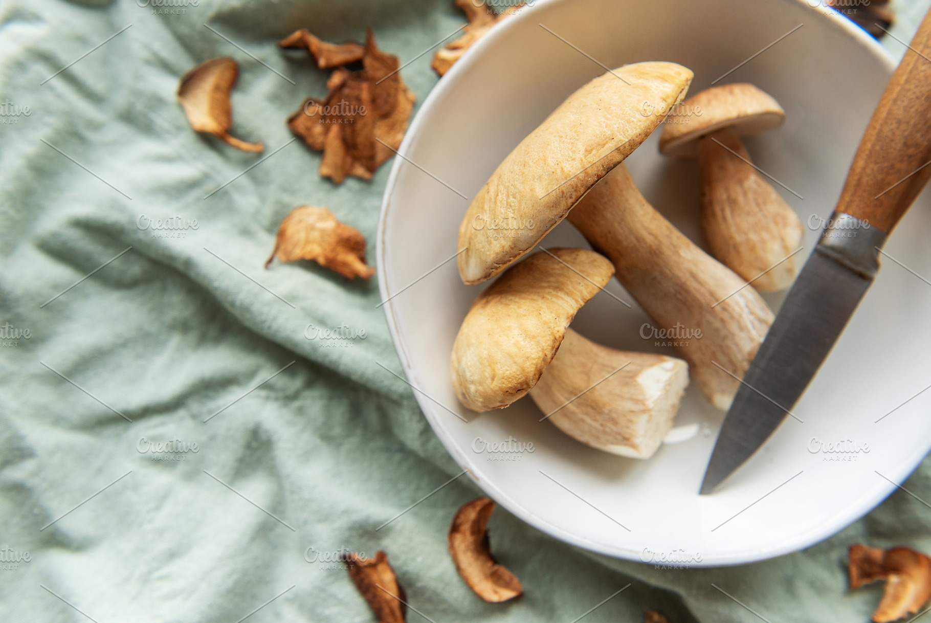 Fresh mushrooms with knife in bowl preparing for cooking, a Food & Drink Photo by Olena Rudo