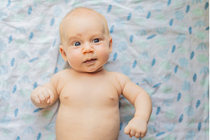 Curious baby lying on a soft blanket, a Person Photo by Elizaveta Galitskaya