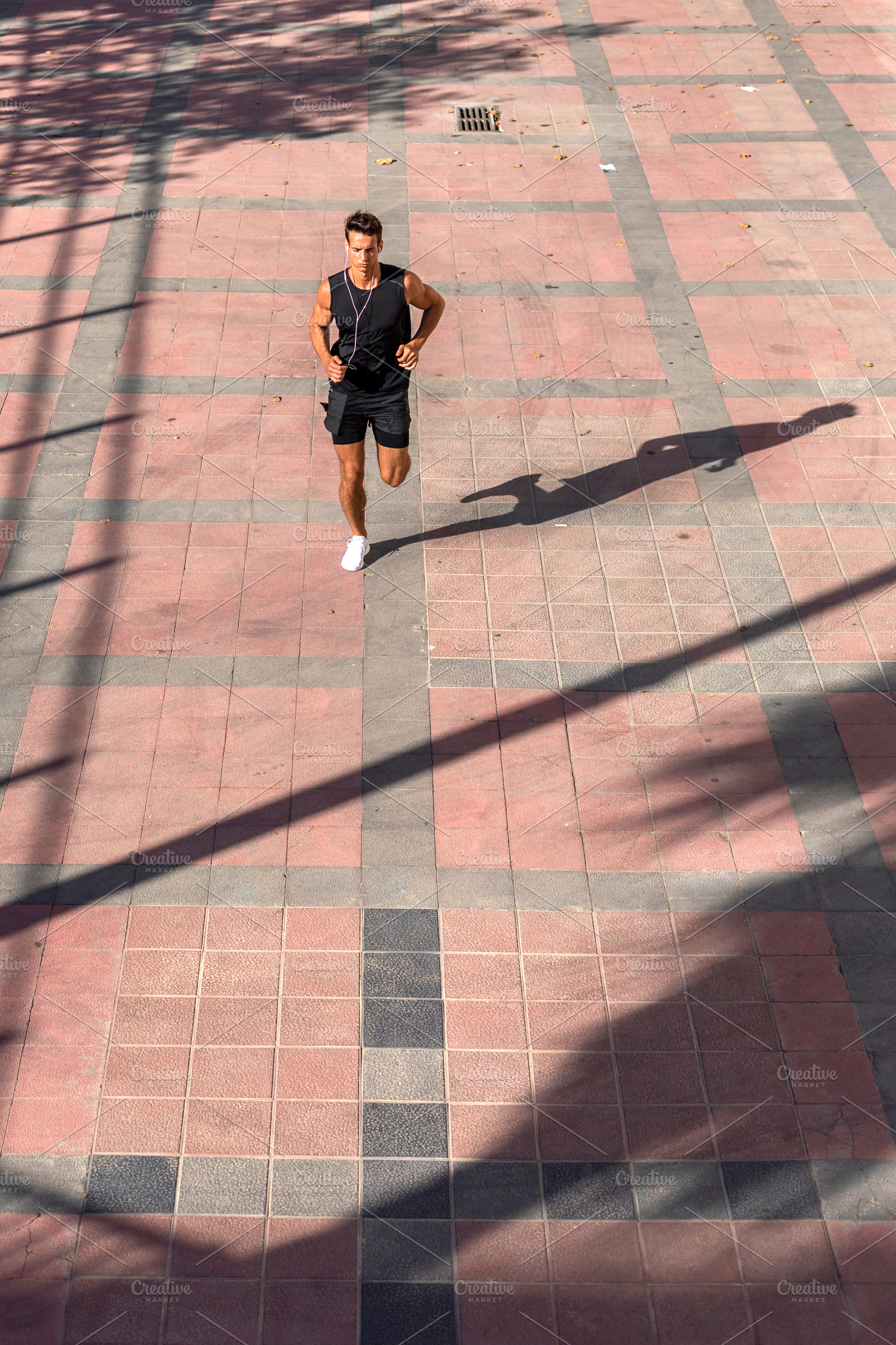 Male runner training on city pavement from above, a Person Photo by RF Images