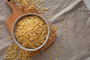 Organic Dried Orzo Pasta in a Bowl, top view. Space for text., a Food & Drink Photo by LiudmylaChuhunova