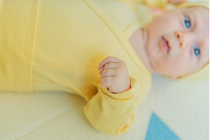 Adorable baby in a yellow hat lying, a Person Photo by Elizaveta Galitskaya