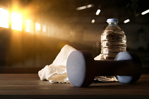 Sport training with dumbbell on wooden bench and gym background, a Sports & Recreation Photo by Davizro's Market